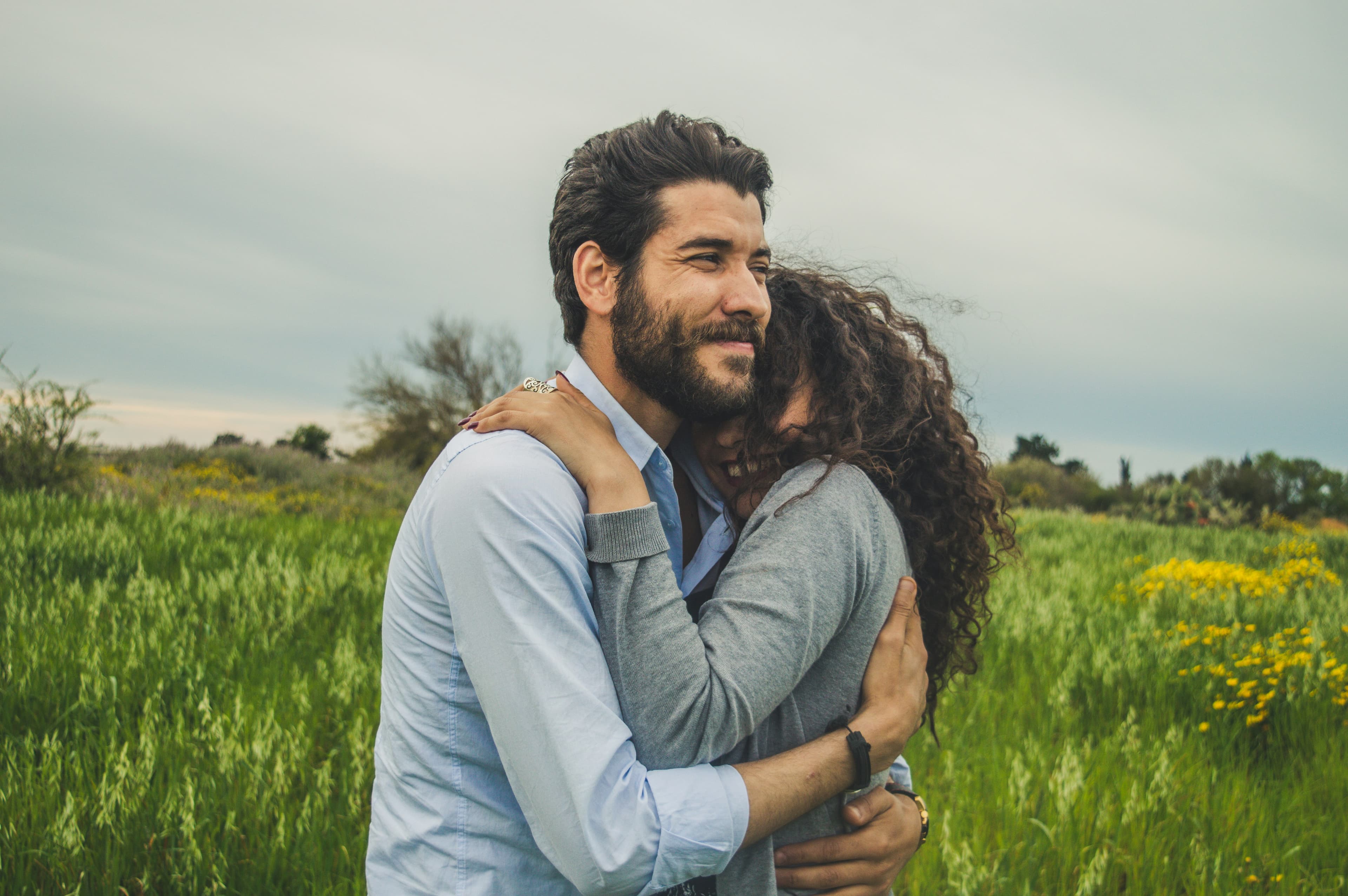 Couple embracing in field - romantic paper anniversary gifts for him